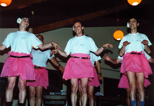 Six men dancing in formation in pink tutus