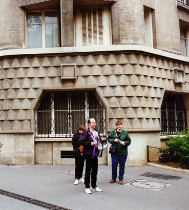 Veronique, Ludwig, and LG standing beside a building and 
some manhole covers